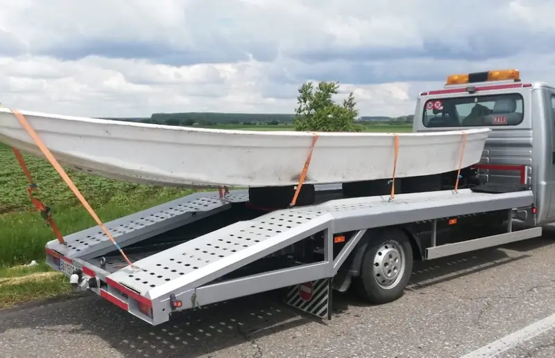 Čamac pričvršćen trakama na platformi šlep vozila